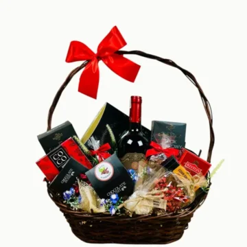 Ekskluzywny kosz wiklinowy z winem i słodkościami.